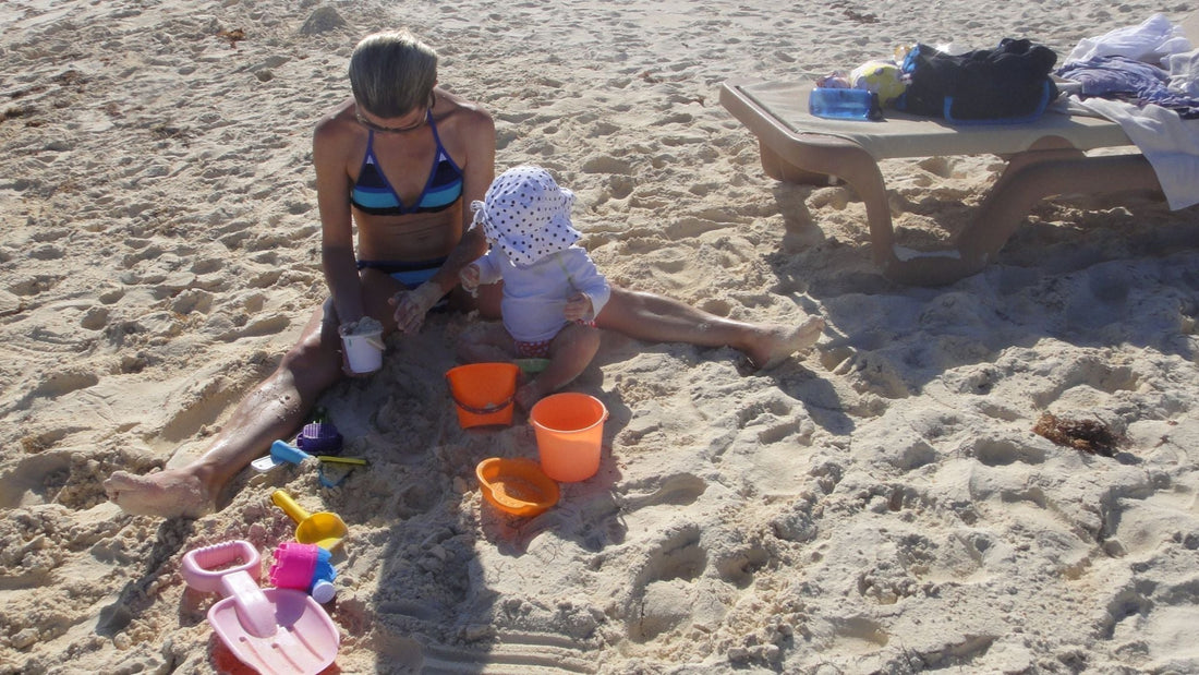 Baby playing with toys at beach while traveling 