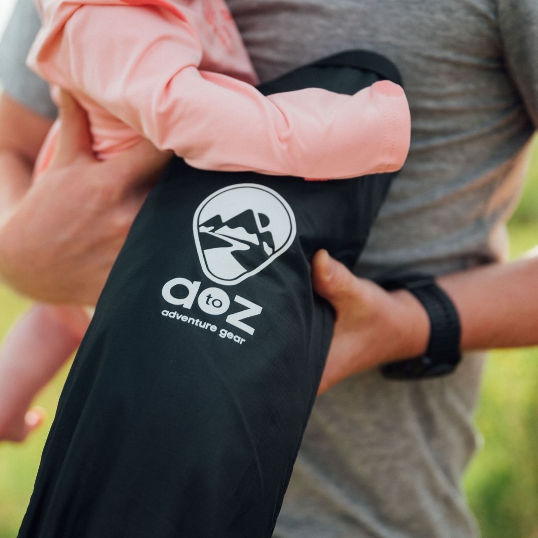 Close-up of soft, textured fabric with colorful embroidered animal patterns on the Adventure Ready Baby Play Mat corner.