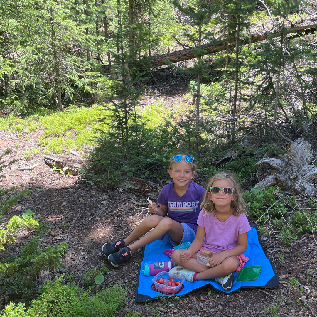 Close-up of the Adventure Mini Mat's textured, waterproof nylon surface with vibrant orange border stitching detail.