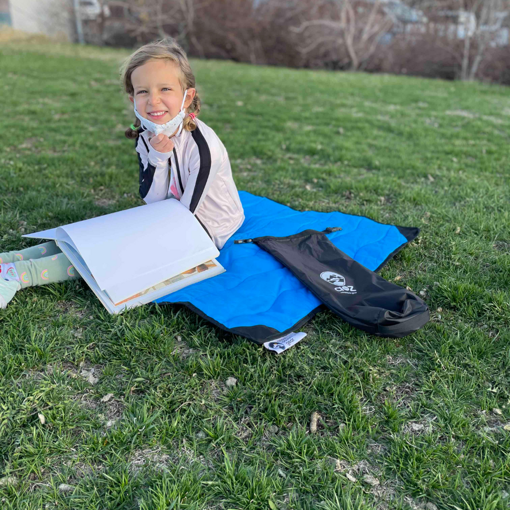 Close-up of the Adventure Mini Mat's textured, non-slip surface with vibrant blue and green fabric edges for outdoor use.